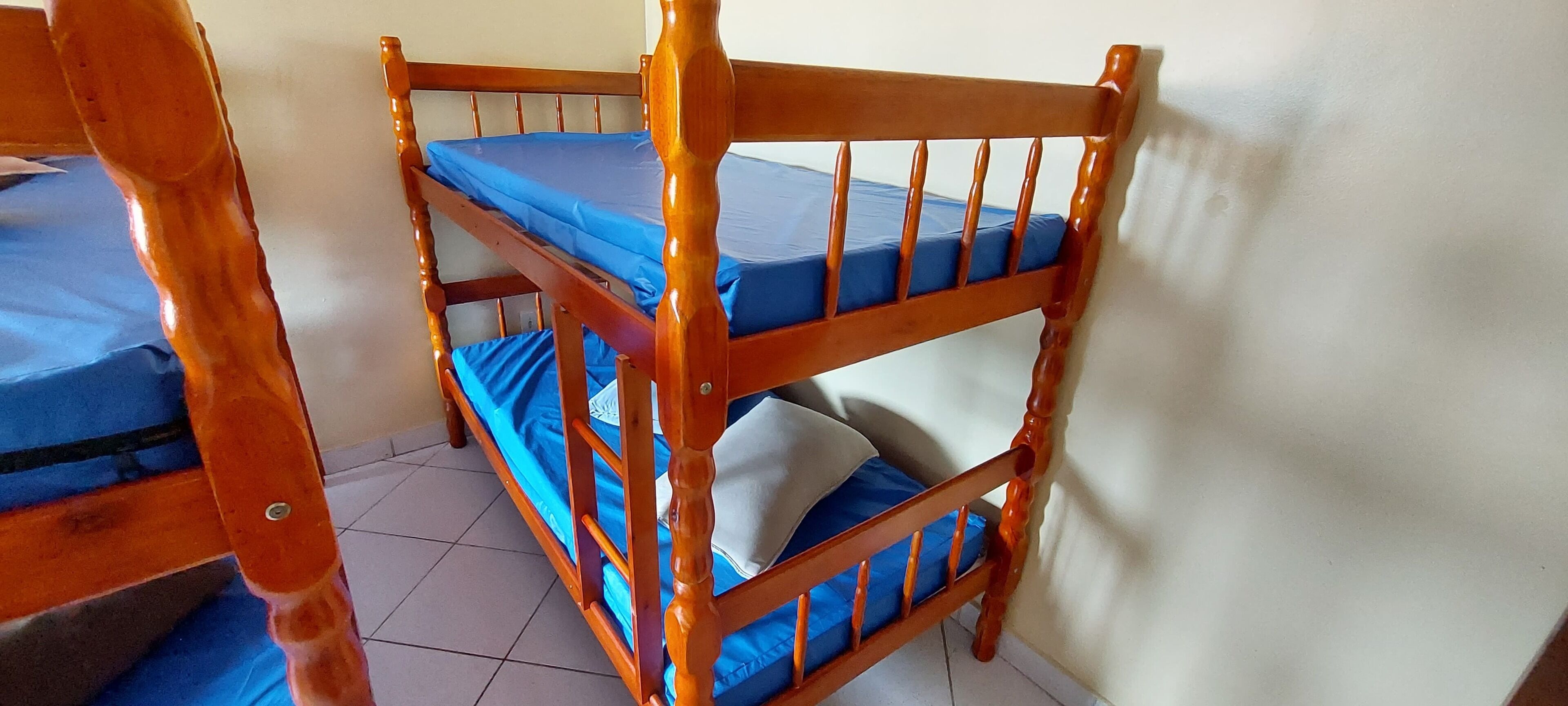 A bunk bed with blue bedding and a wooden headboard.