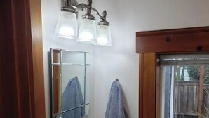 A bathroom with a white sink, a mirror, and two wall-mounted lights.