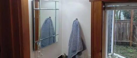 Un bagno con un lavandino bianco, uno specchio e due luci a parete.