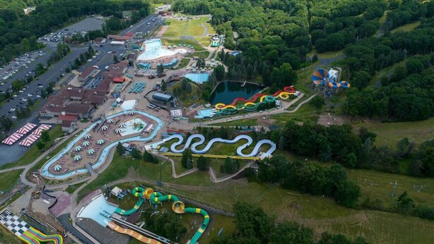 An aerial view of a theme park with various attractions, including a winding water slide, a large pool, and a racetrack. - Spectacular Pocono's Getaway Near EVERYTHING!!! (Tannersville)