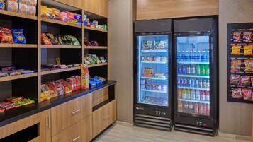 A snack and beverage vending area with multiple shelves stocked with various snacks and drinks.