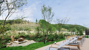A deck with outdoor seating and a garden area with rocks and greenery. - Fairfield by Marriott Okayama Hiruzen Highland (Maniwa)