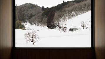A snowy landscape with a cabin and trees.