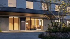 A modern hotel entrance with a glass facade, a sign reading "Fairfield," and a well-lit interior visible through the doors. - Fairfield by Marriott Okayama Hiruzen Highland (Maniwa)
