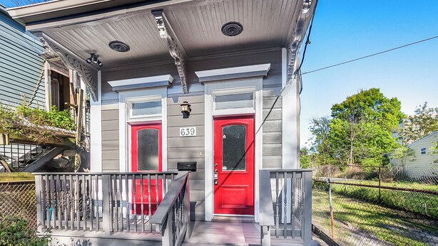 A two-story house with a red door and a number 639 on the front.