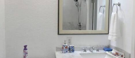 Een badkamer met een witte wastafel, spiegel en toilet.