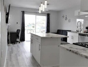 Enjoy cooking in the well-equipped kitchen with a central island, stainless steel stove, and dining area.