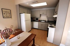 Enjoy meals in this kitchen with a dining table, refrigerator, and stove.