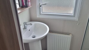 A bathroom with a white sink, a window, and a radiator. - Lovely 8 Berth Direct Beach Access (Skegness)