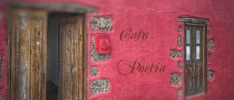 A rustic building facade with wooden doors and a red mailbox.