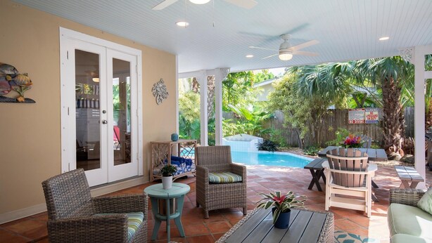 A covered patio area with wicker furniture, a pool, and a view of the backyard. - Tranquil Beauty-Private Pool - Outside Lanai-Beaches Nearby (Key West)