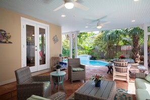 A covered patio area with wicker furniture, a pool, and a view of the backyard. - Tranquil Beauty-Private Pool - Outside Lanai-Beaches Nearby (Key West)