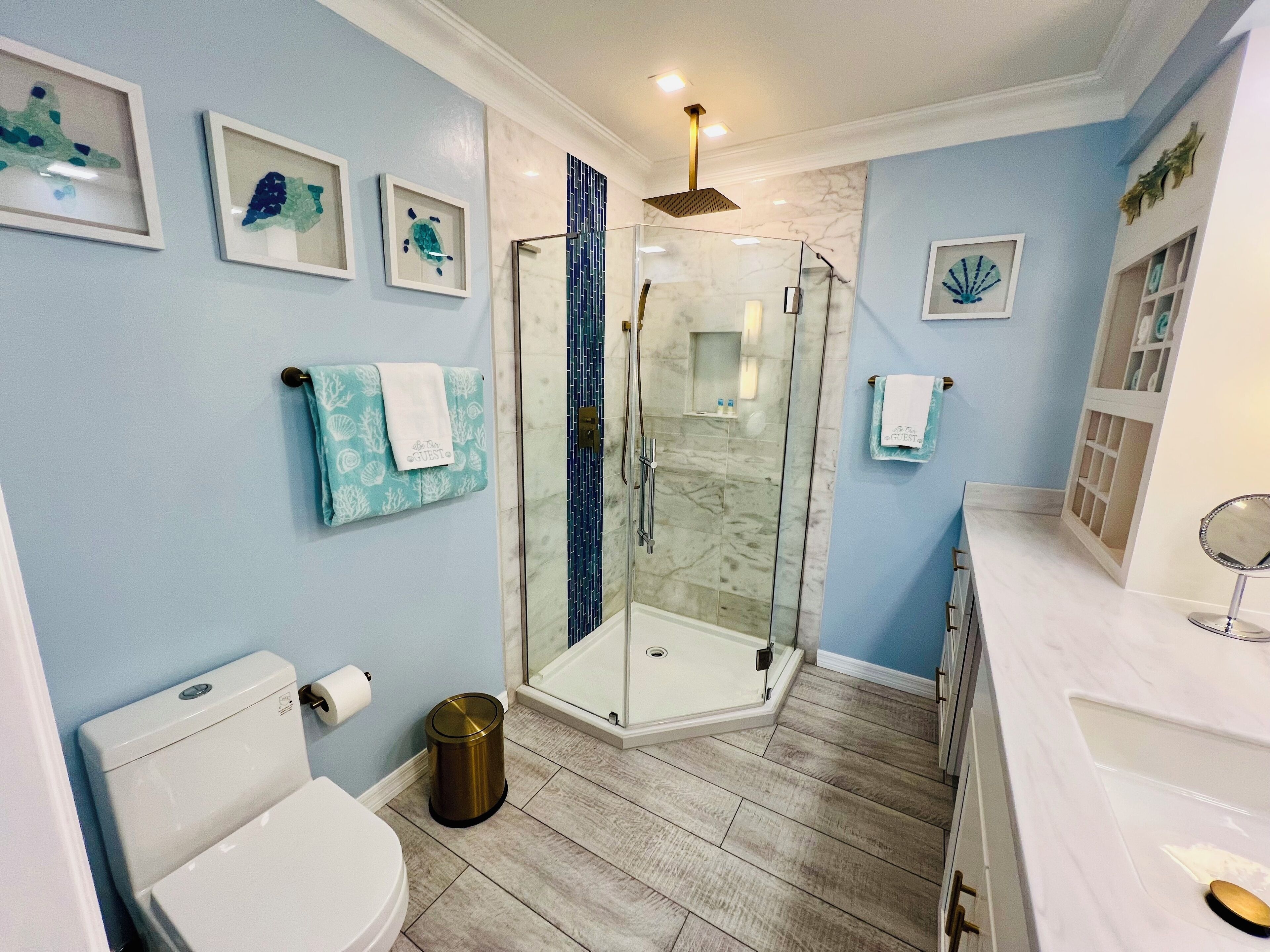 A bathroom with a toilet, shower, and sink.