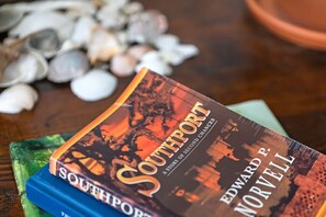 Un livre intitulé « Southport : une histoire de seconde chance » d’Edward P. Norvell, posé sur une surface en bois, avec des coquillages en arrière-plan.