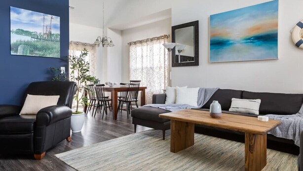 Ein modernes Wohnzimmer mit einer Couch, einem Couchtisch und einem Essbereich mit Stühlen und einem Tisch.