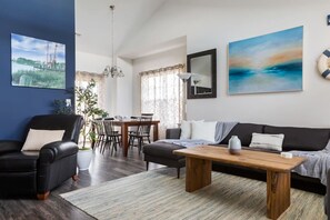 Un salon moderne comprenant un canapé, une table basse et un coin repas avec des chaises et une table.