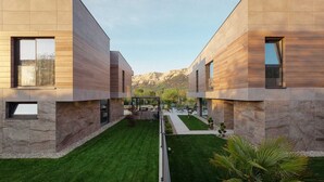 Un edificio moderno con un diseño simétrico, con ventanas amplias y un césped cuidado.