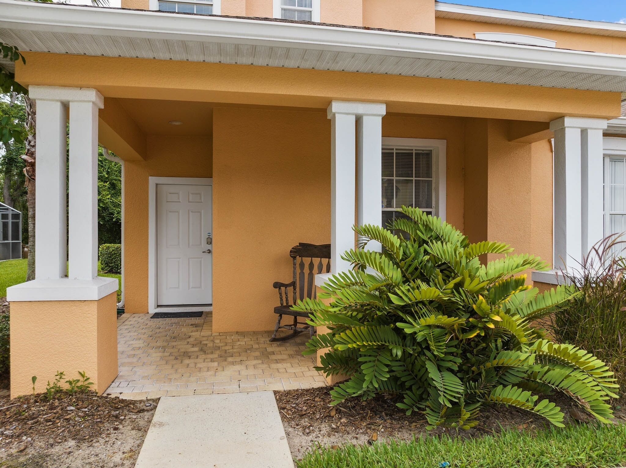 A house with a porch, a door, and a small garden.