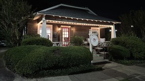 Een houten huis met veranda, een brievenbus en een bord waarop staat dat het een herenigingshuis is.