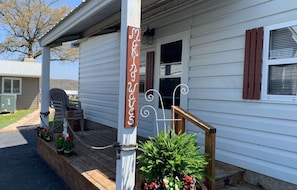 Enjoy a relaxing moment on the front porch with a comfortable bench and a beautiful potted plant.