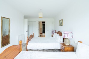 2 habitaciones, escritorio y tabla de planchar con plancha