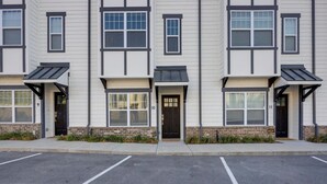 A row of townhouses with a parking lot in front.
