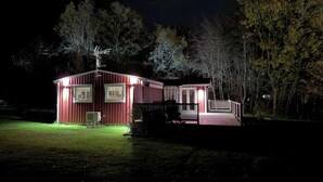 A small, single-story cabin with a red exterior, a covered porch, and a satellite dish. - Wonderful house with new kitchen in beautiful nature and close to activities (Skåne län)