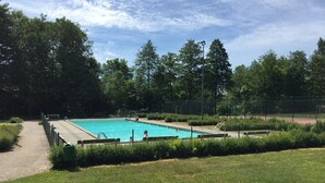 A swimming pool surrounded by a fence, with a wooden deck and benches. - Wonderful house with new kitchen in beautiful nature and close to activities (Skåne län)