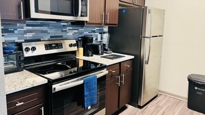 A modern kitchen with a microwave, stove, oven, refrigerator, and coffee maker. - Total Relaxation and Tranquility - Perfect space for family or work . (The Woodlands)