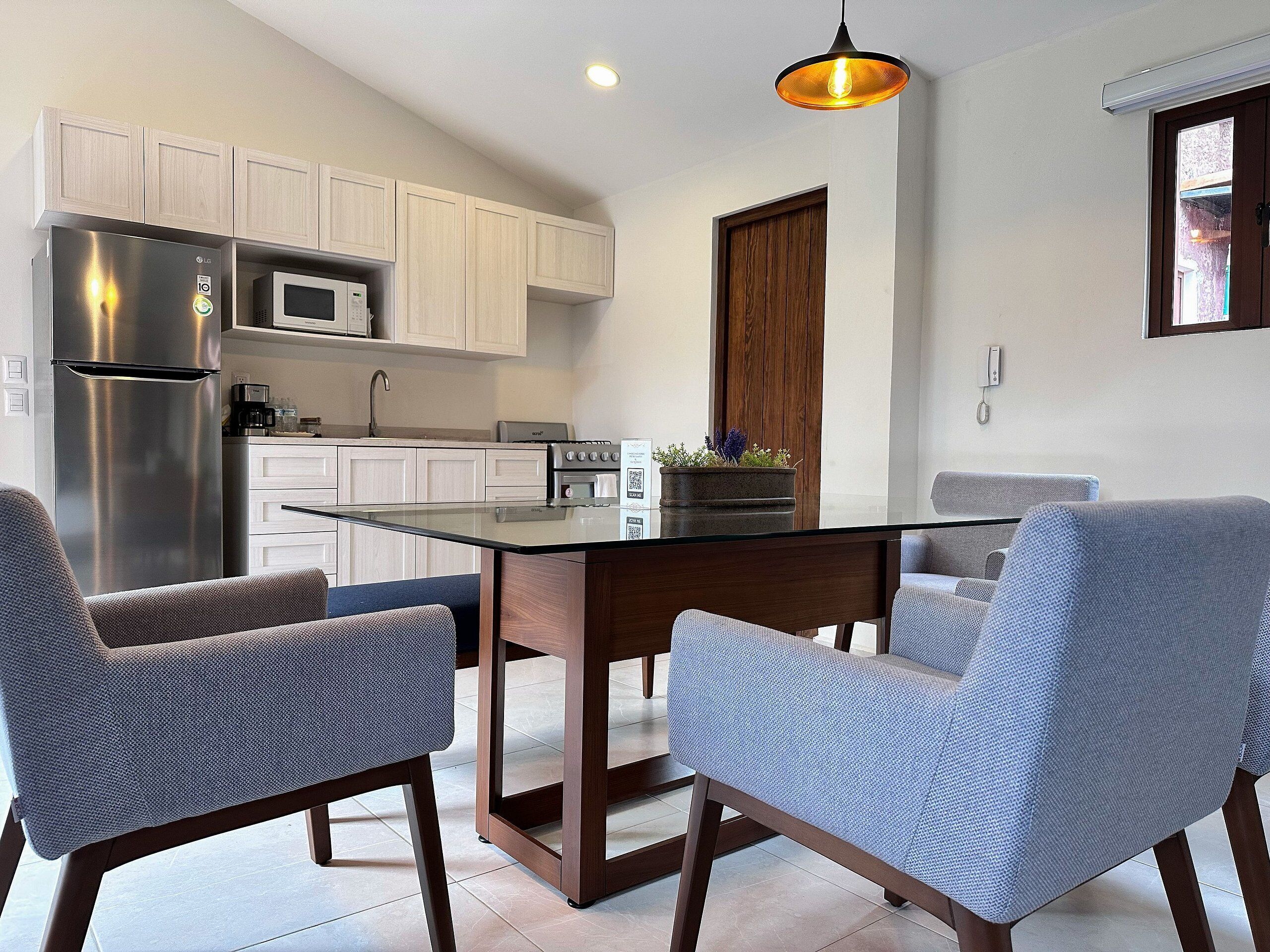 A modern kitchen with white cabinets, stainless steel appliances, and a central island with chairs.