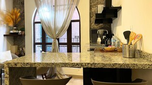 Una cocina con encimeras de granito, cafetera y utensilios en un organizador.