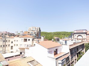A hotel with a prominent archway, surrounded by residential buildings and greenery. - Bravissimo Eiximenis, beautiful terrace and views (Girona)