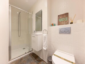 A modern bathroom with a glass shower enclosure, a white sink, and a toilet. - Bravissimo Eiximenis, beautiful terrace and views (Girona)