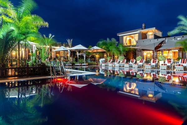 Una piscina al aire libre, sillones reclinables de piscina