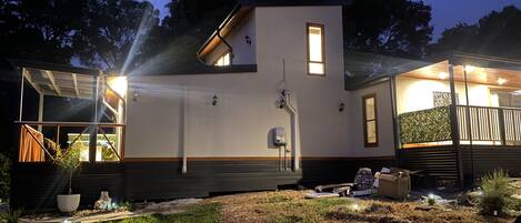 Een modern huis met een plat dak, een klein balkon en een opvallende schoorsteen.
