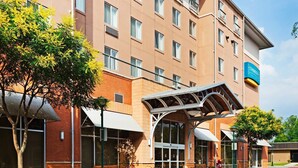 Un hotel con entrada cubierta, varias ventanas y mobiliario para disfrutar al aire libre.