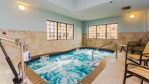A hot tub with a tiled floor, two windows, and a chair near the tub. - Pool and Hot Tub. Near University of North Dakota (Grand Forks)