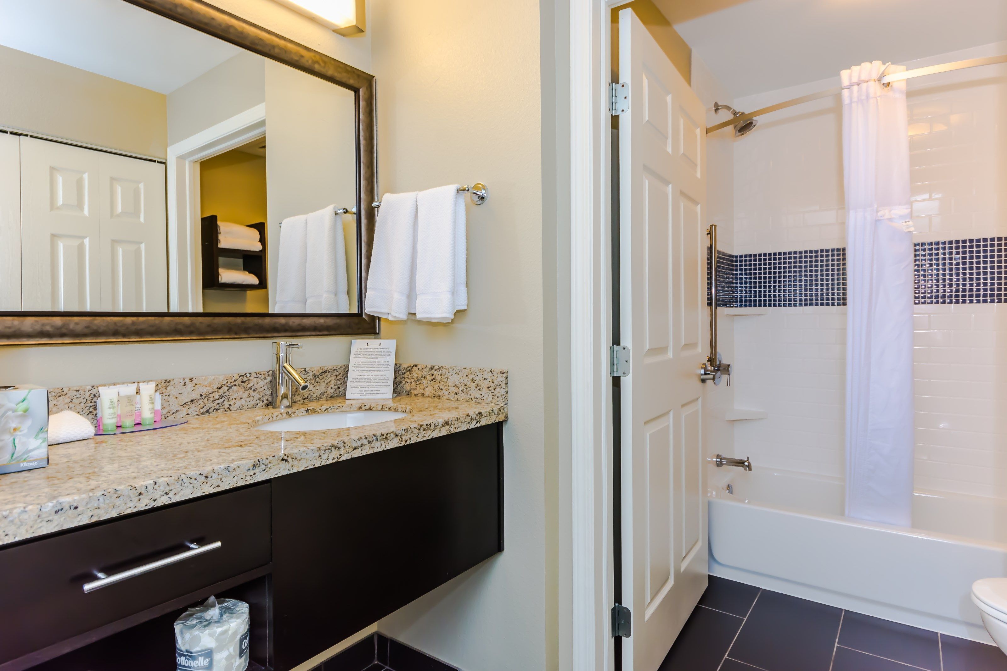 Een badkamer met een wastafel, spiegel en douche.