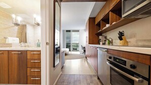 Eine moderne Küche mit Holzausbau, einem eingebauten Backofen und einer digitalen Uhr, die die Uhrzeit anzeigt.