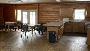 Una cocina amplia con armarios de madera, un comedor con sillas y una isla grande.