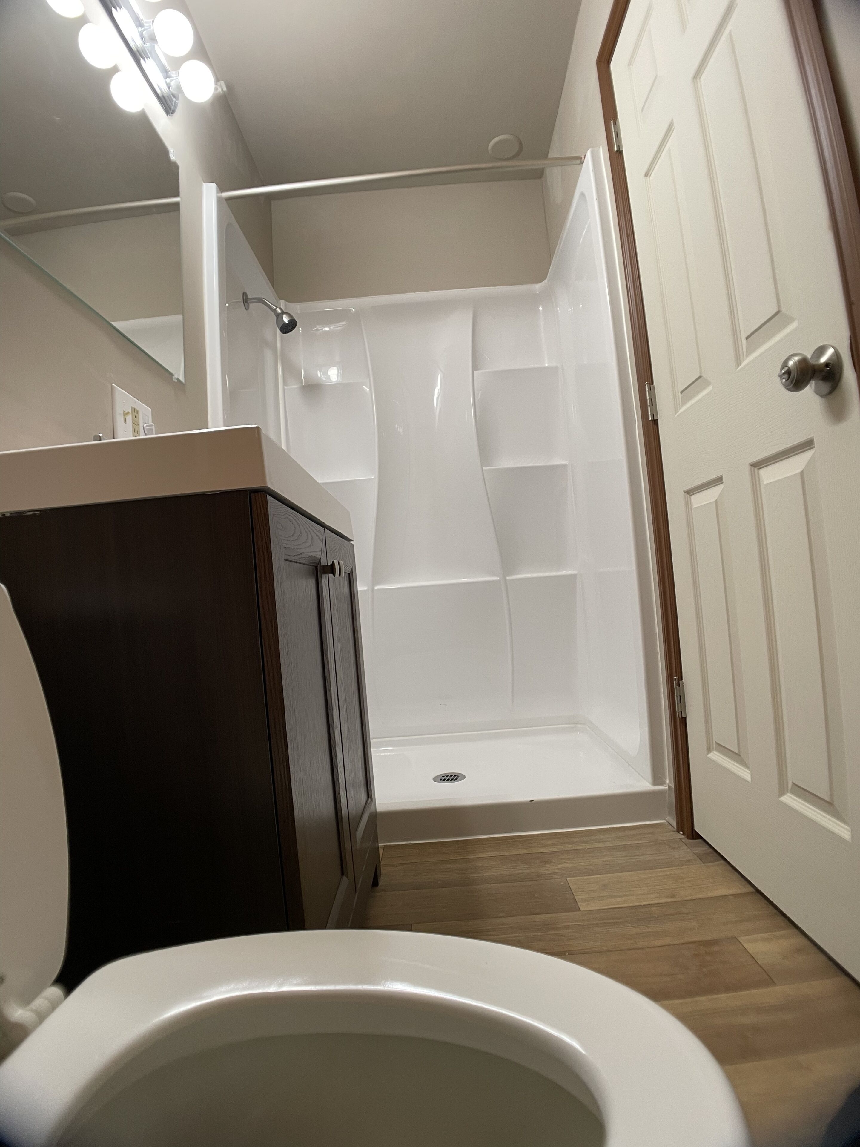 A bathroom with a shower, toilet, and vanity.