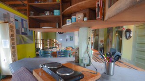 A kitchen with wooden cabinets, a stove, and various kitchen utensils. - Michie Hostel (Providence)