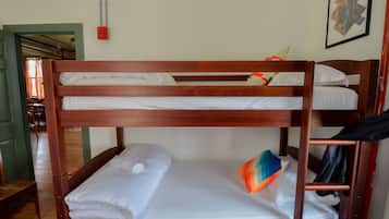 A bunk bed with white bedding and a colorful pillow.