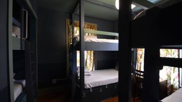 A bunk bed room with a window, a chair, and a door.