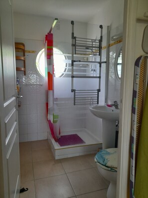 Een douche, handdoeken, zeep, toiletpapier