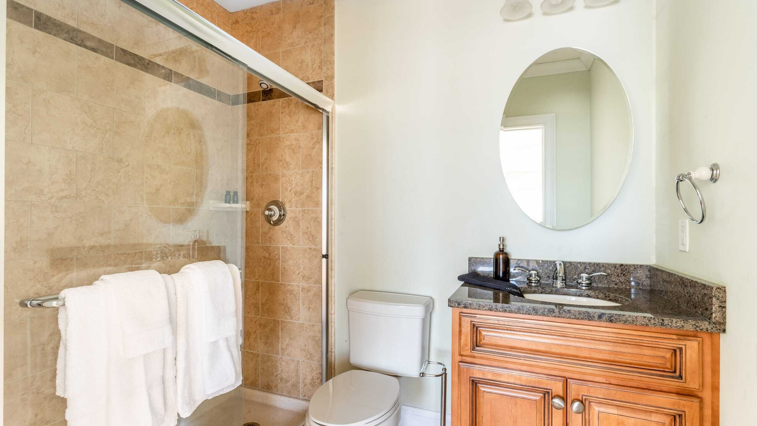 Un baño con ducha, inodoro, lavamanos y tocador.