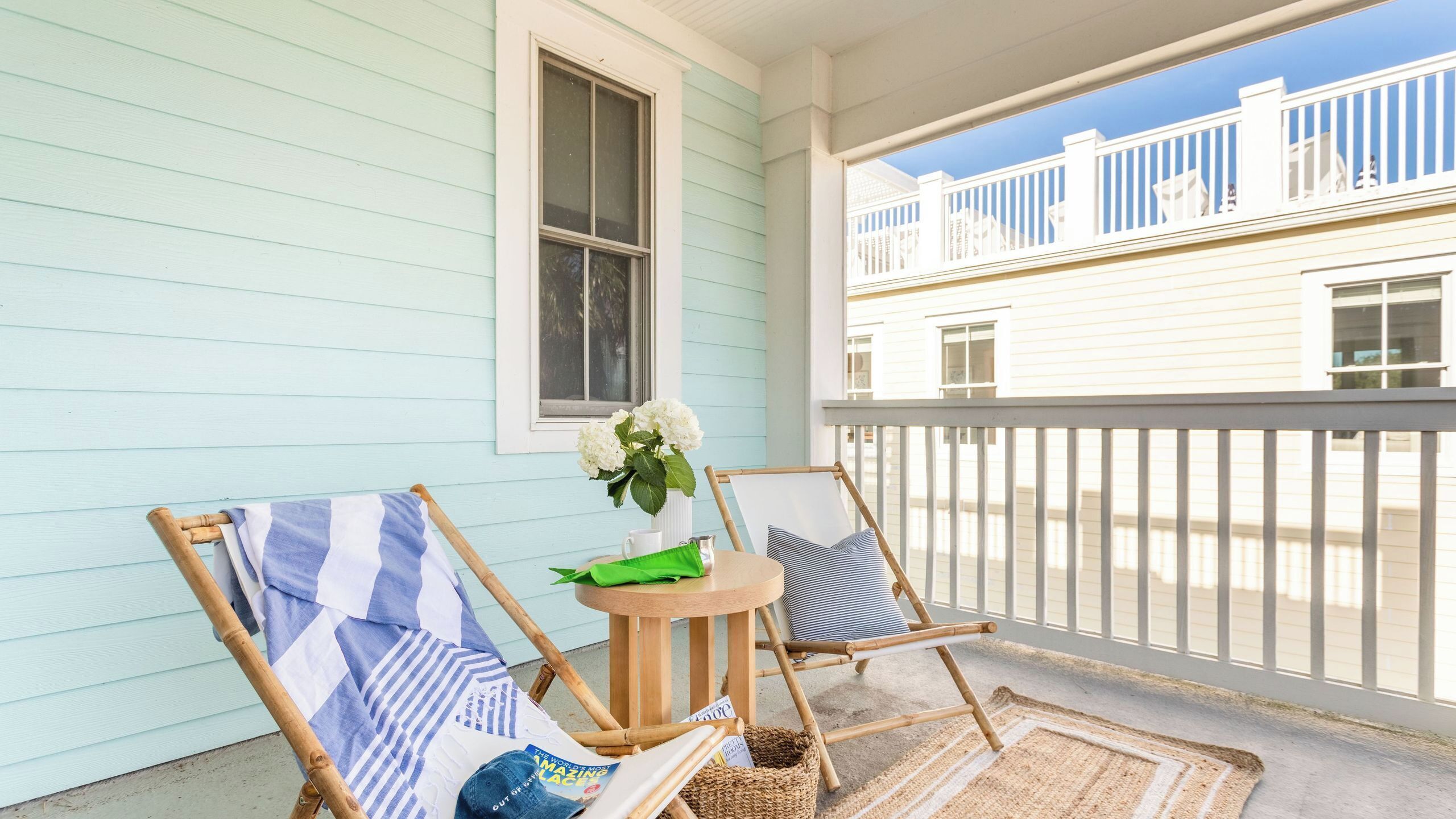 A porch with two chairs, a small table, and a window.