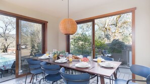 A dining area with a table set for breakfast, large windows, and a view of the outdoors. - 3.5-acre 5bdr Rereat w/ Views, Pool + Hot Tub, Fire Pit Gable by Avantstay (Santa Rosa)