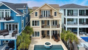 A multi-story residential building with a pool, outdoor seating, and a covered patio area. - Oceanfront, Pool+hot Tub, Game Room, Views Steps to Beach Lido by Avantstay (Hilton Head Island)