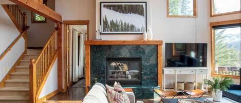 A spacious living room with a fireplace, a large TV, and a cozy seating area.